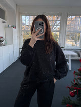 Oversized Oberteil mit Glitzer und Ballonärmeln, kürzer vorne, länger hinten – Gr. 36-42 schwarz